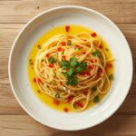 quick spaghetti aglio e olio with golden garlic parsley on white plate