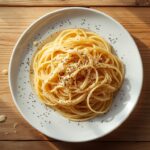 simple cacio e pepe pasta with creamy pecorino sauce on white ceramic plate