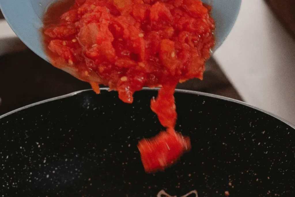adding canned tomatoes marinara.webp